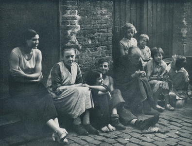 716616 Groepsportret van enkele vrouwen en kinderen zittend op straat, vermoedelijk in de Jordaan te Amsterdam.